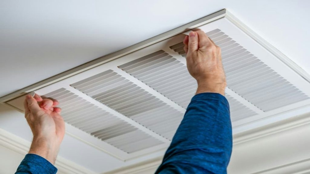 Technician working on a ceiling-mounted air conditioning unit